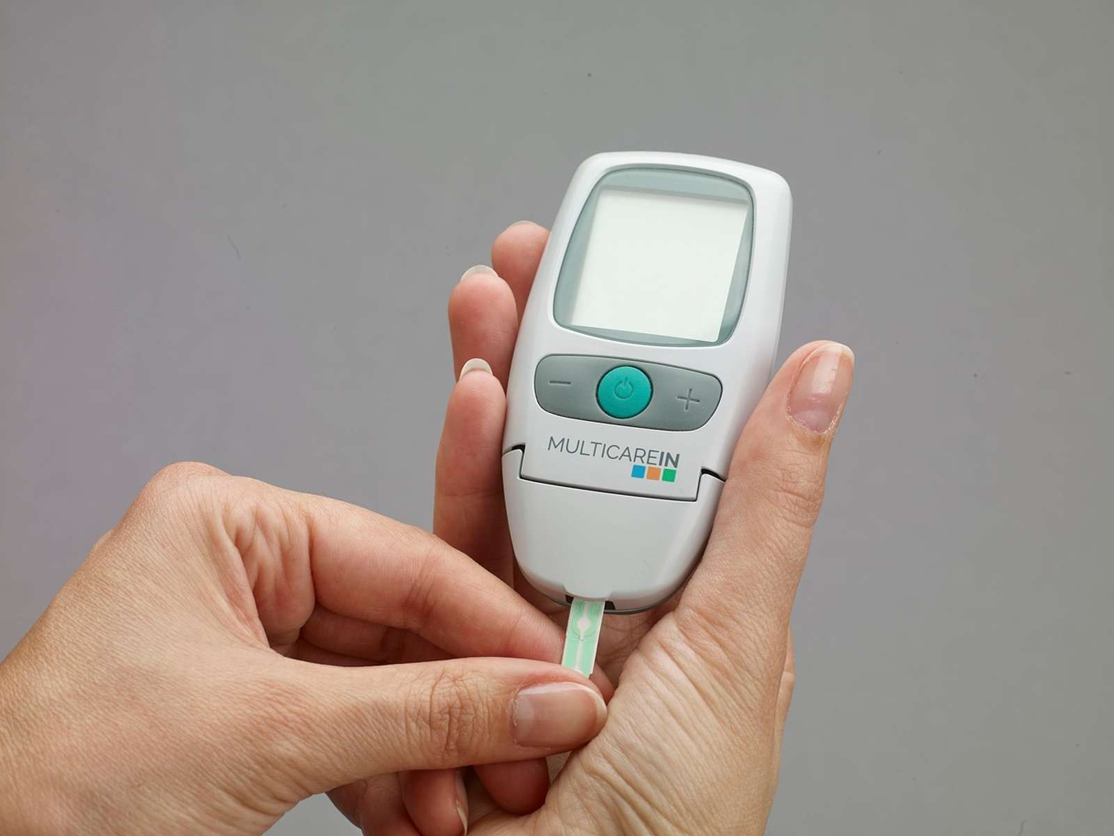 A digital blood glucose meter device lying on a table