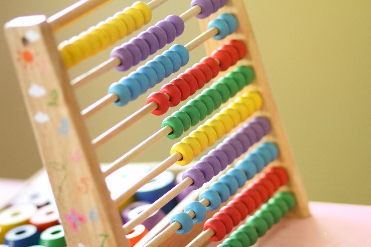 Children counting with an abacus in a classroom