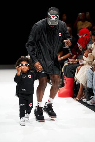 A designer takes his kid on the runway.