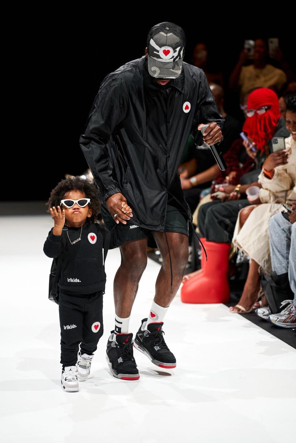 A designer takes his kid on the runway.