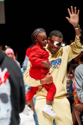 A designer takes his kid on the runway.