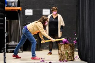 Britt practices axing a cabbage during rehearsal.