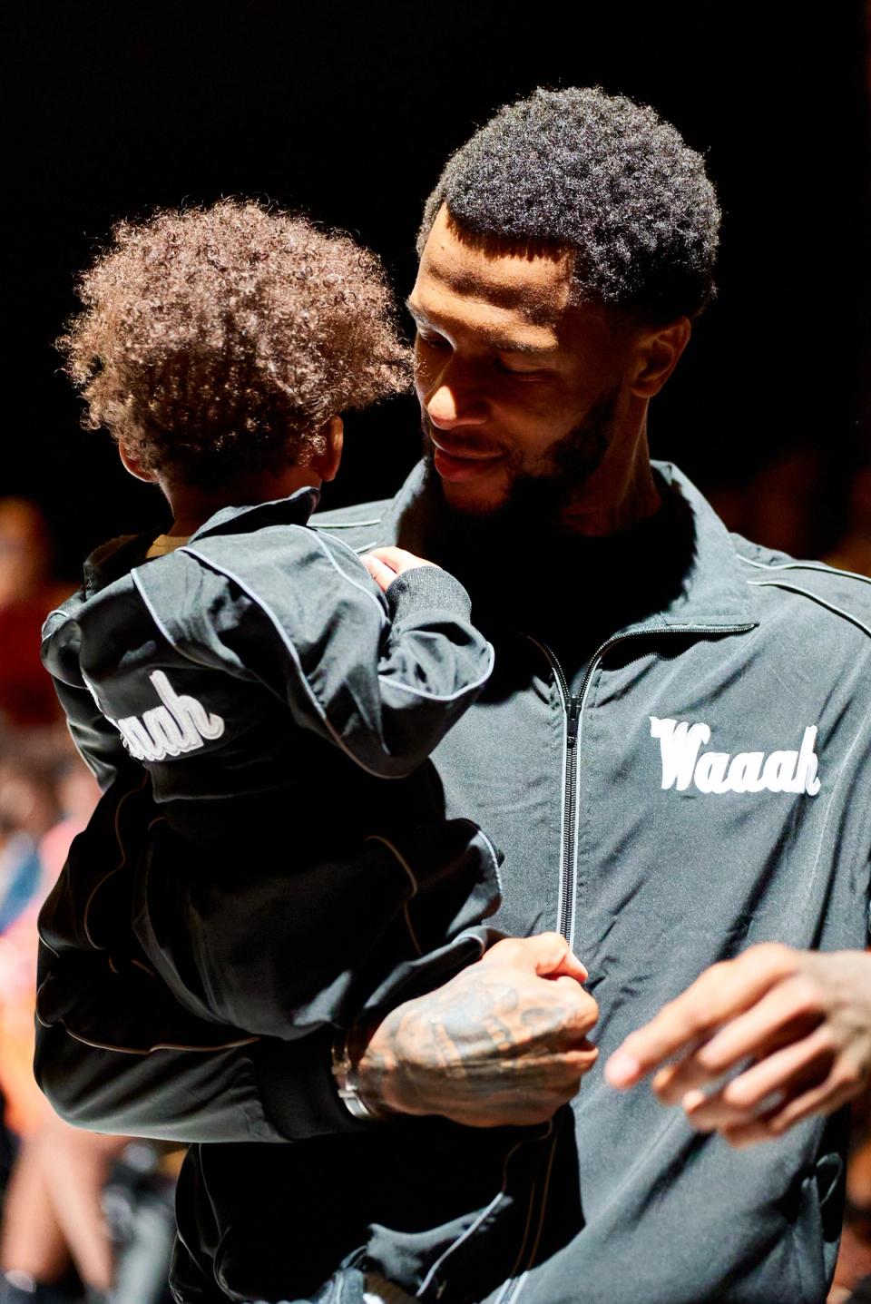 A designer takes his kid on the runway.