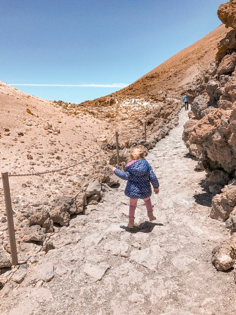 Una niña pequeña subiendo por el sendero pedregoso del mirador de Pico Viejo