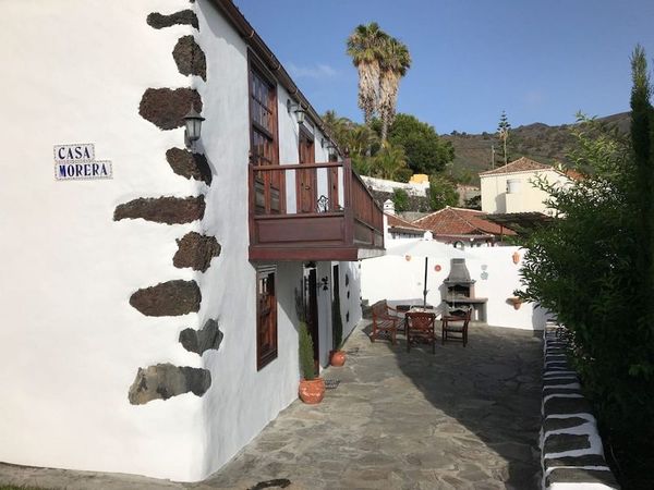 Casa Morera, casa rural de dos plantas con fachada blanca y piedra volcánica vista, con su patio y barbacoa, en Fuencaliente de La Palma