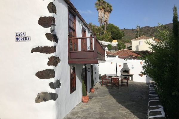 Casa Morera, casa rural de dos plantas con fachada blanca y piedra volcánica vista, con su patio y barbacoa, en Fuencaliente de La Palma