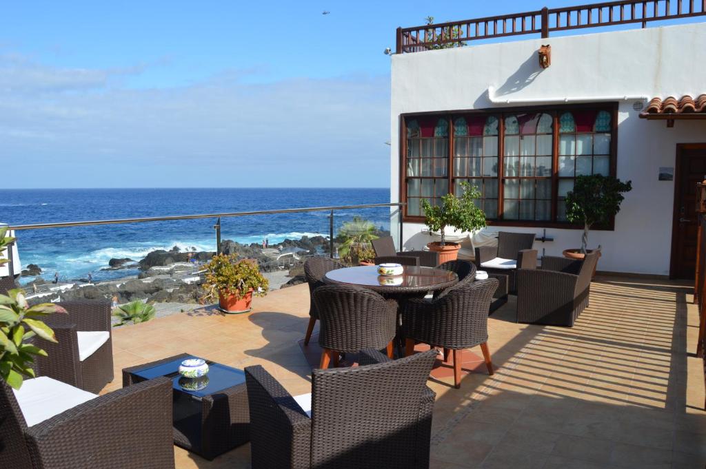 Terraza del Gara Hotel en Garachico, con sillones de mimbre y mesas frente al mar y las rocas de El Caletón.