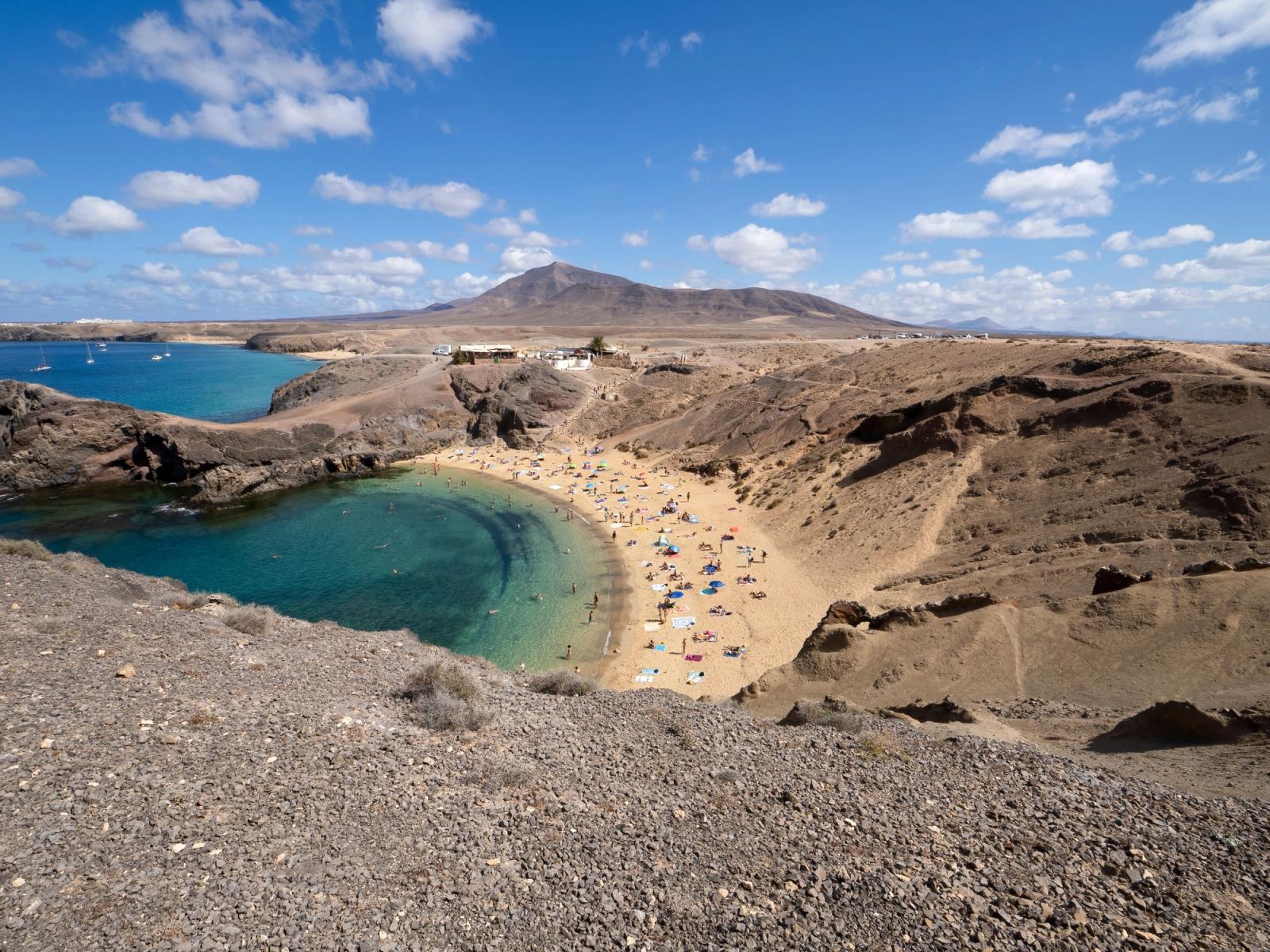 La playa de Papagayo vista desde lo alto, con su cala de aguas turquesas y arena dorada