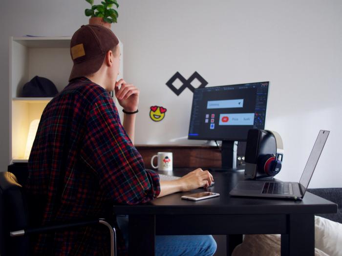 a man is sitting at a desk with a laptop and a computer .