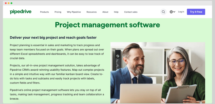 Pipedrive's project management software page featuring a man and woman collaborating with a laptop and tablet.