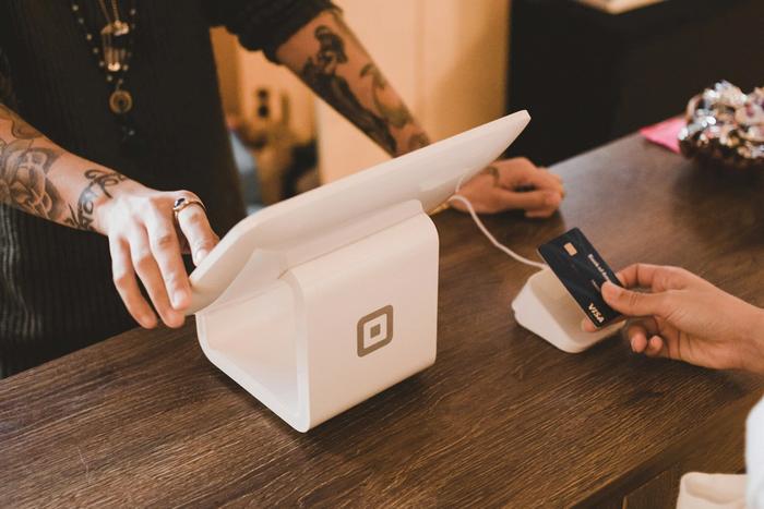 a person is paying with a credit card at a counter