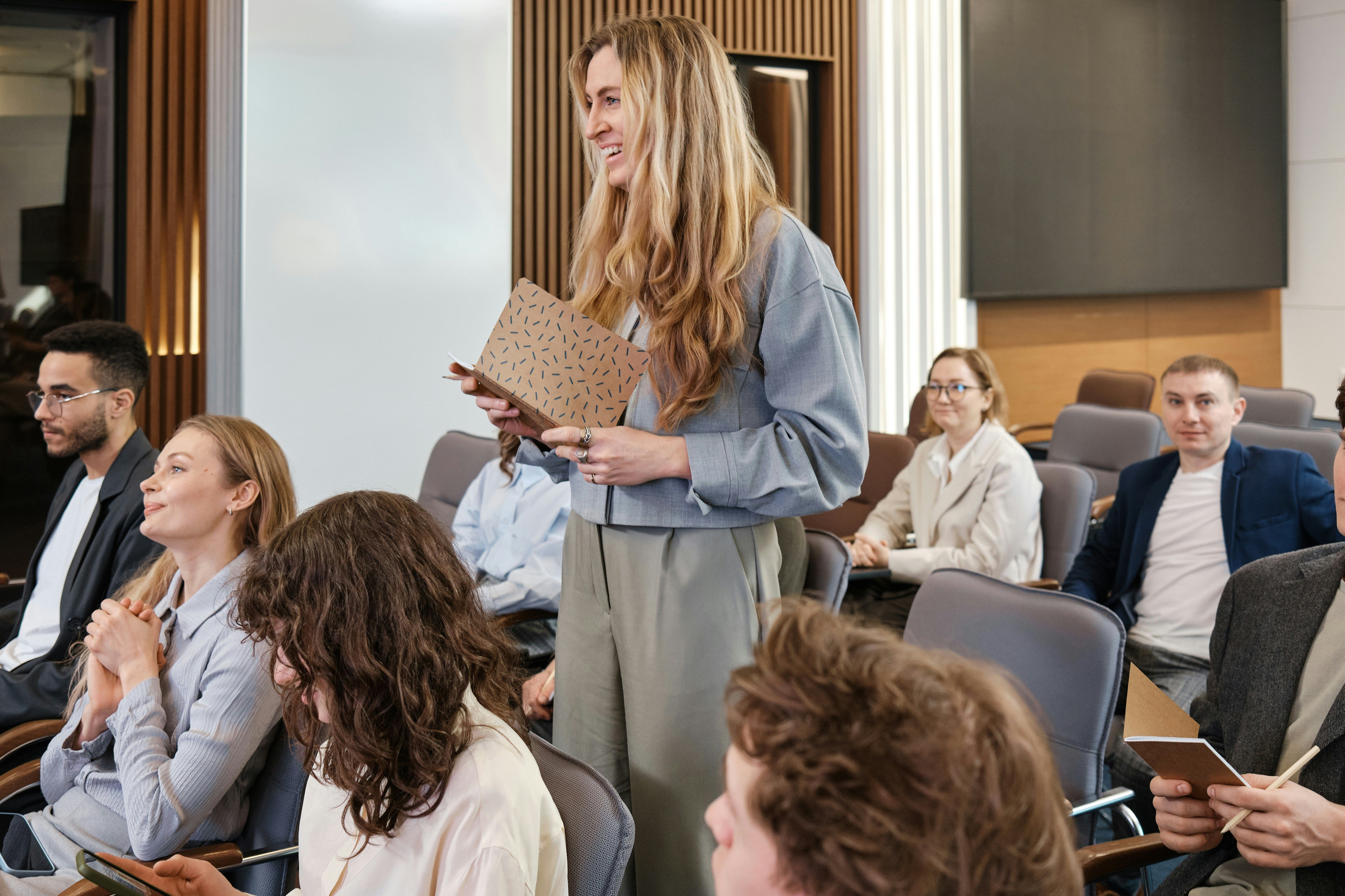 woman holding a notebook standing up at a conference
