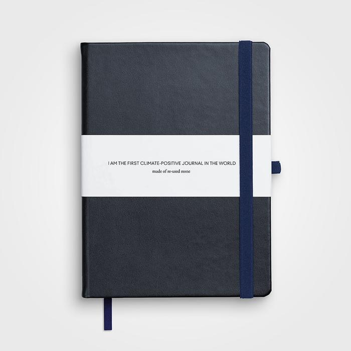 A black notebook with a blue strap and a white label.