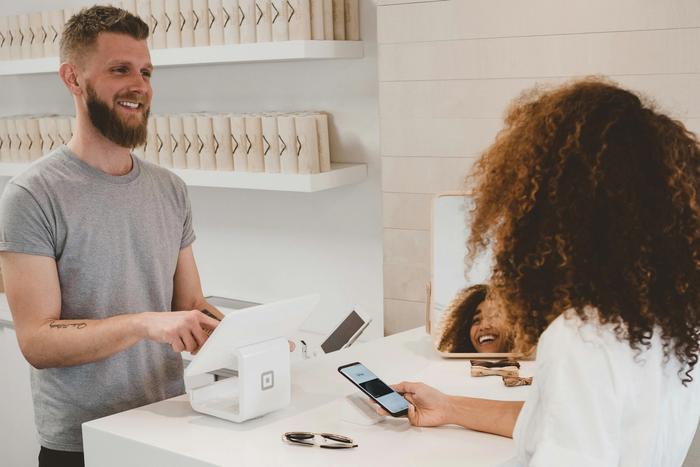 a shop worker helping someone make a payment
