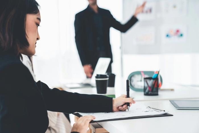 a woman making notes in a meeting