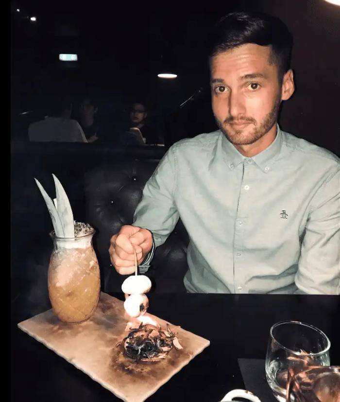 a man is sitting at a table with a penguin shirt on