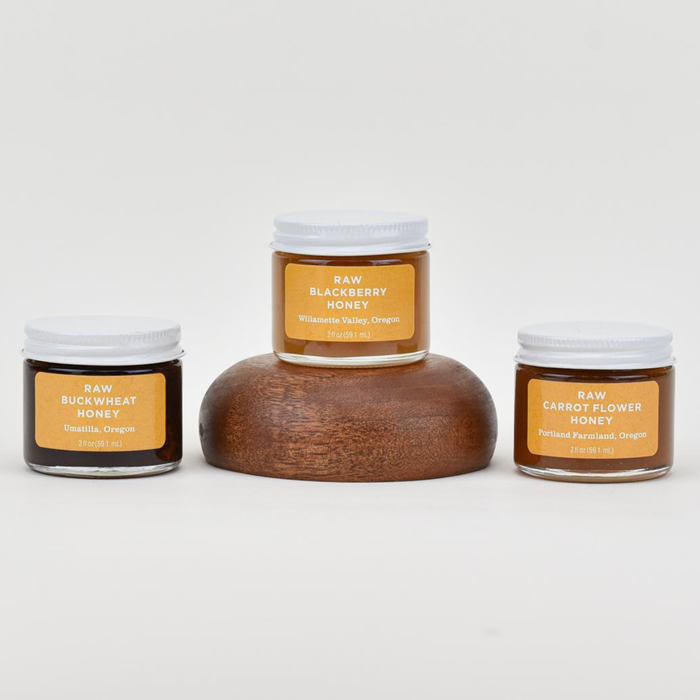 Jars of raw honey including blackberry honey and carrot flower honey.
