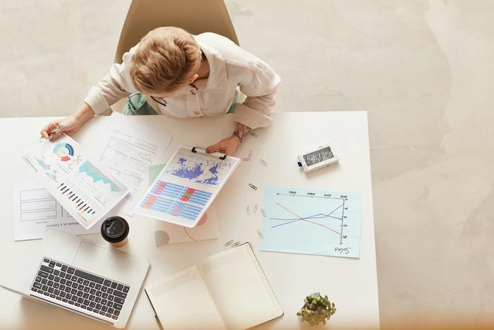 An office worker analyzes graphs at a desk