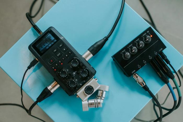 a recorder and a mixer are sitting on top of a blue table .