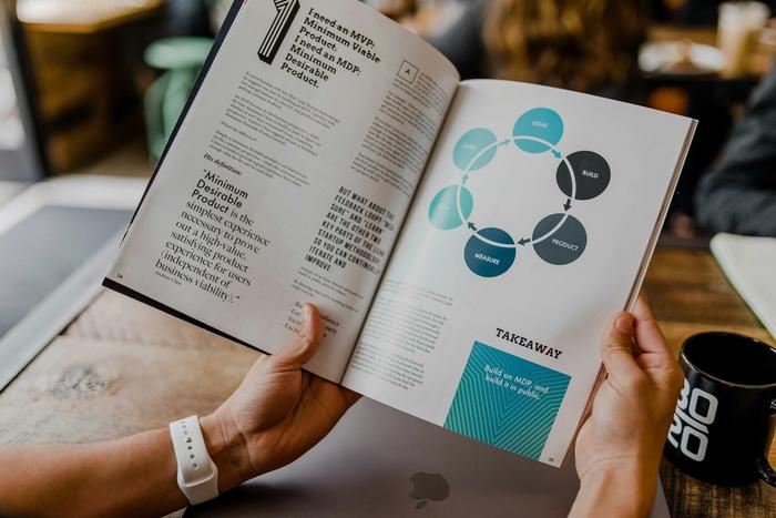 a person is holding a magazine in their hand .