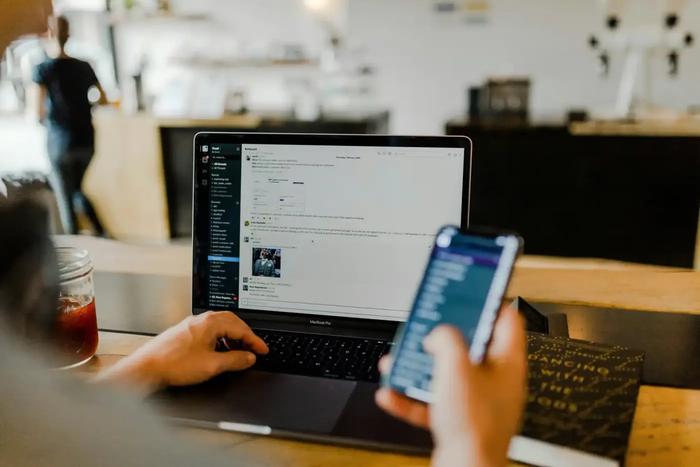 a person is using a laptop and a cell phone at the same time .