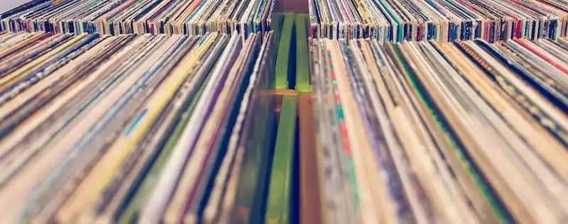 a bunch of records are stacked on top of each other on a shelf .