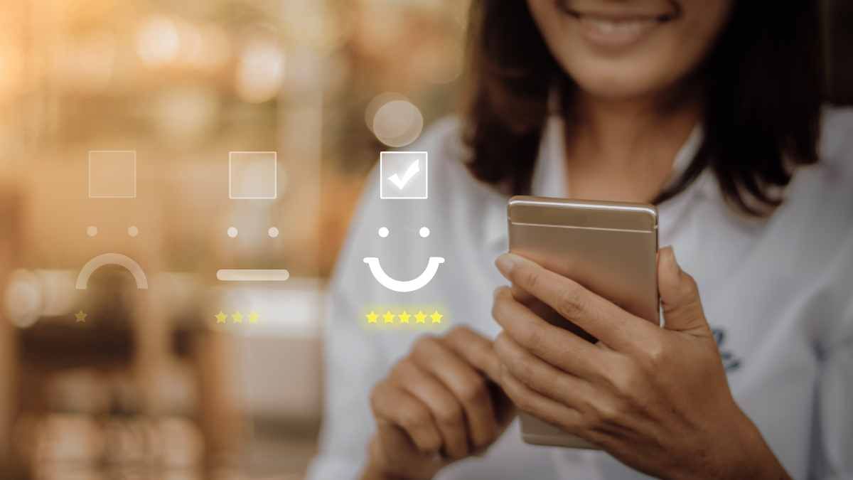Una mujer sosteniendo un teléfono celular con una cara sonriente en él.