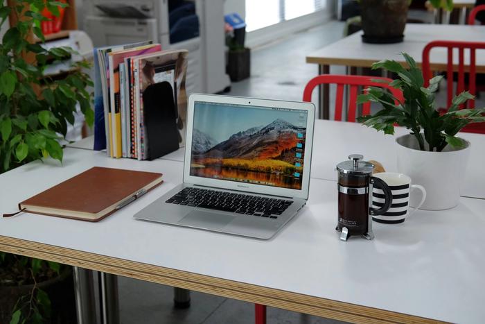 a laptop computer is sitting on a desk next to a cup of coffee .