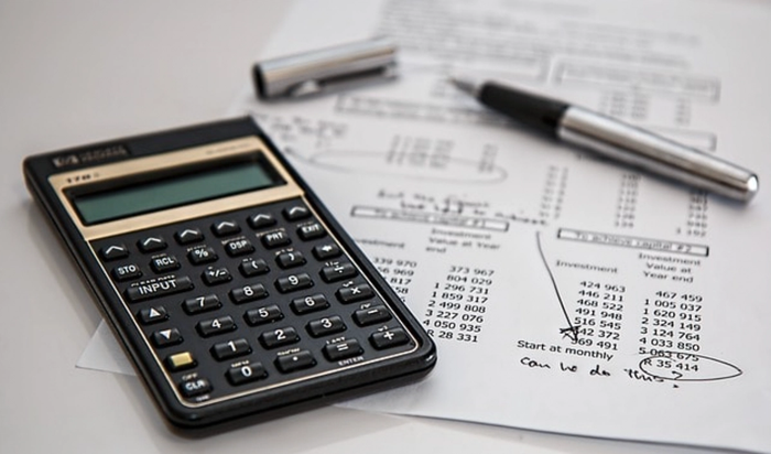 a calculator sits on top of a sheet of paper with numbers on it