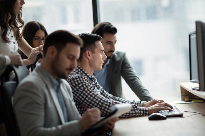 a group gathered around a computer