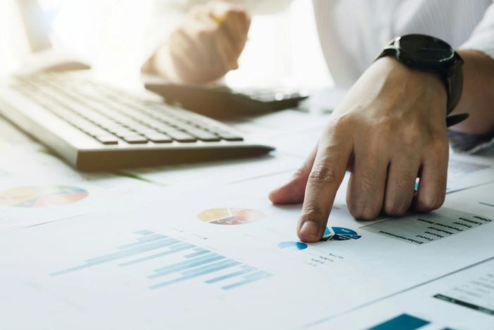 Man looking at charts and using a calculator