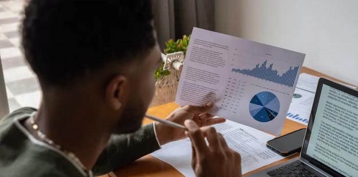 Person reading financial document at desk