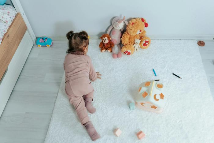 a little girl is laying on the floor playing with toys .