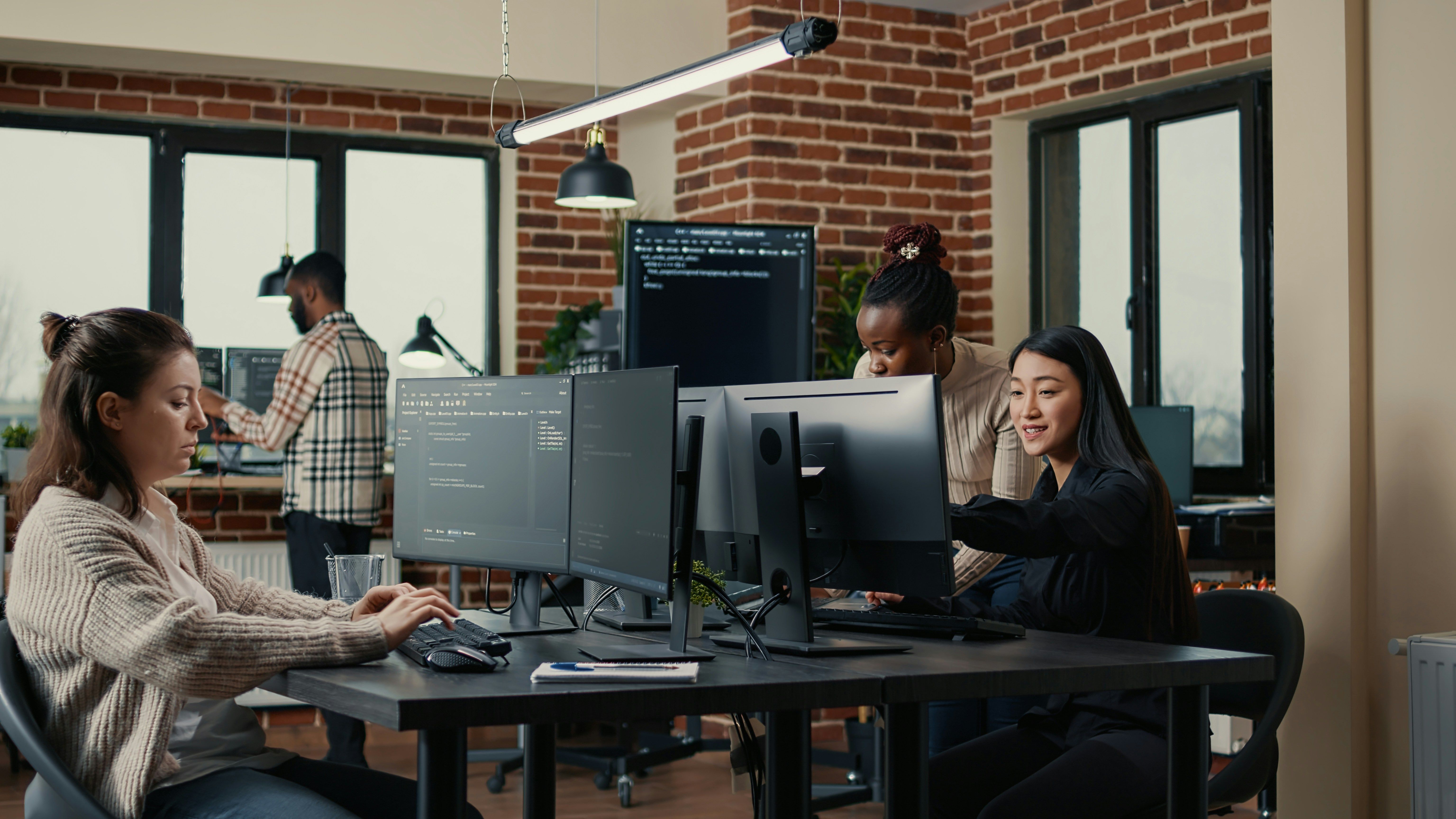 a group of people are working on computers in an office .