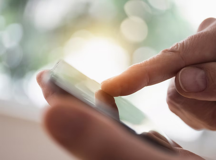 Close-up of a person's finger touching a smartphone screen.