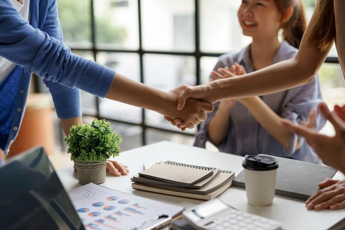 a group of people are shaking hands over a table .