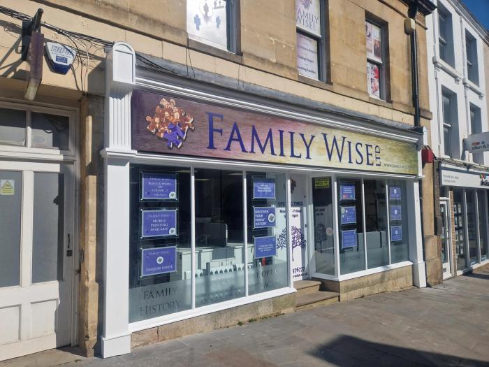 the front of a family wise estate agency on a city street .