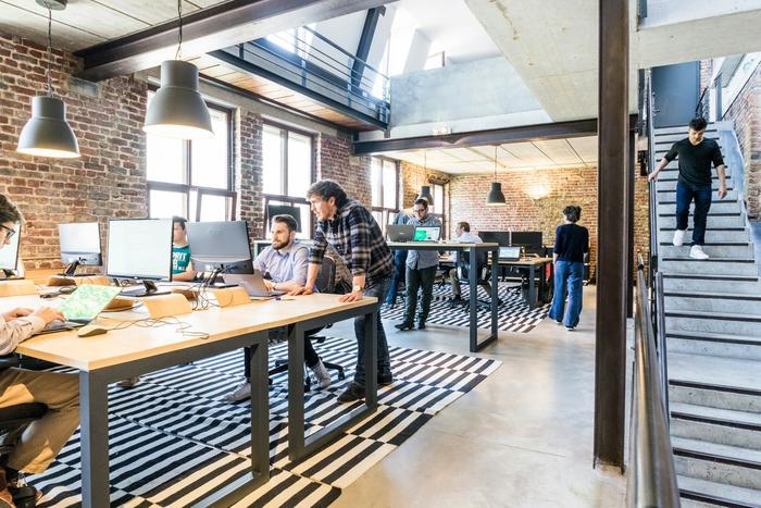 a group of people are sitting at desks in an office .