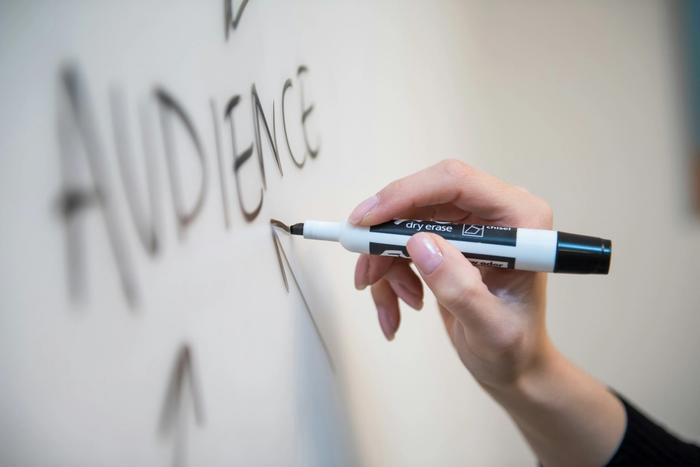 a person is writing on a whiteboard with a marker .