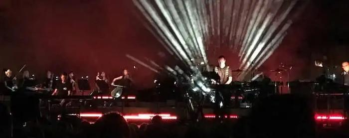 a group of people are standing on a stage in front of a crowd .