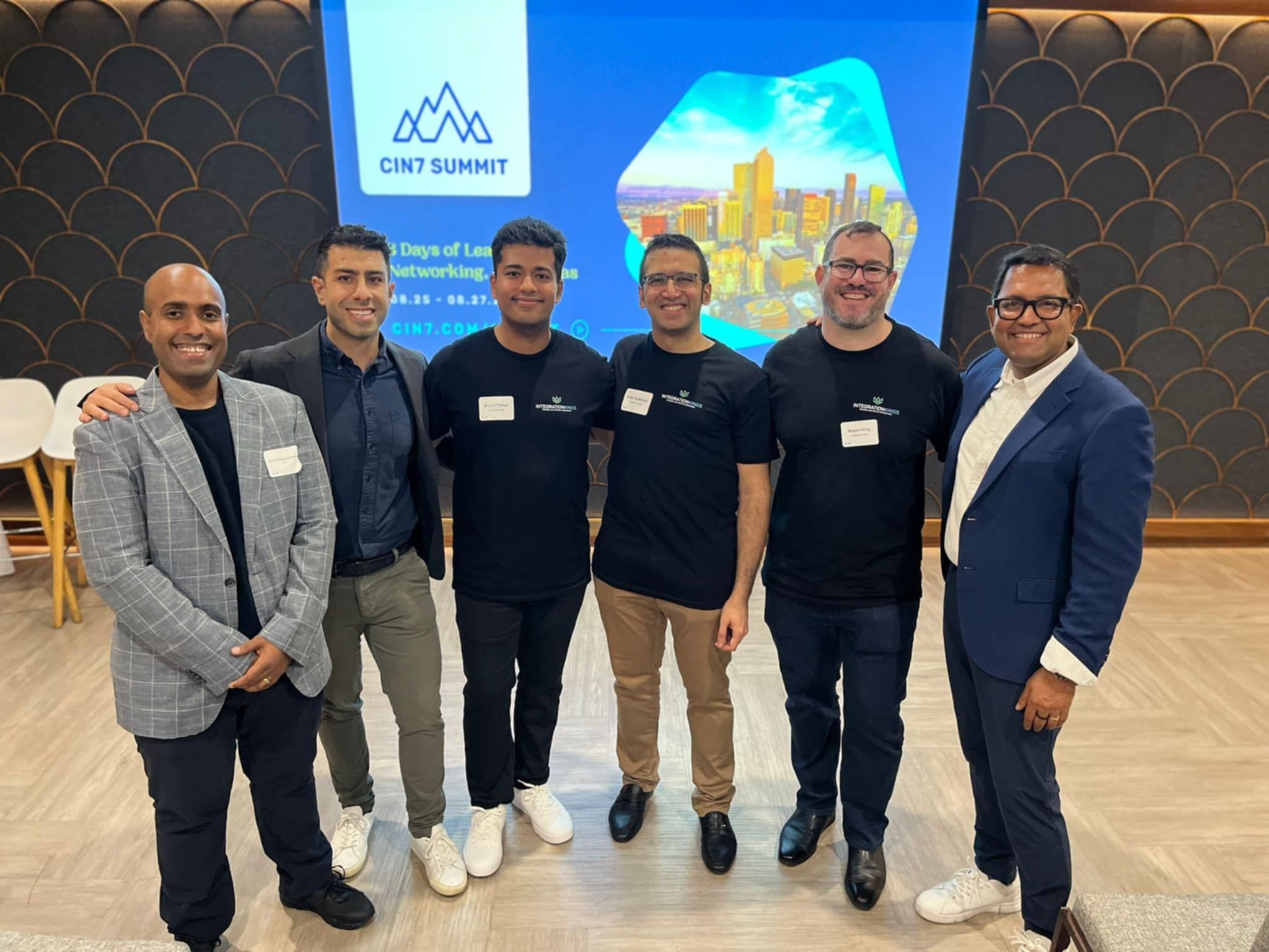 un grupo de empleados de Integration Kings posan juntos para una foto en una habitación.