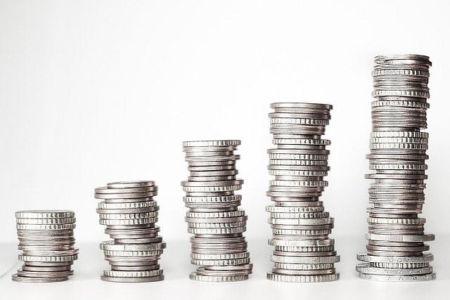 a stack of silver coins stacked on top of each other on a white surface .
