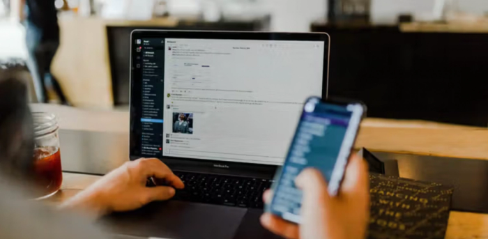 a person is using a laptop and a cell phone