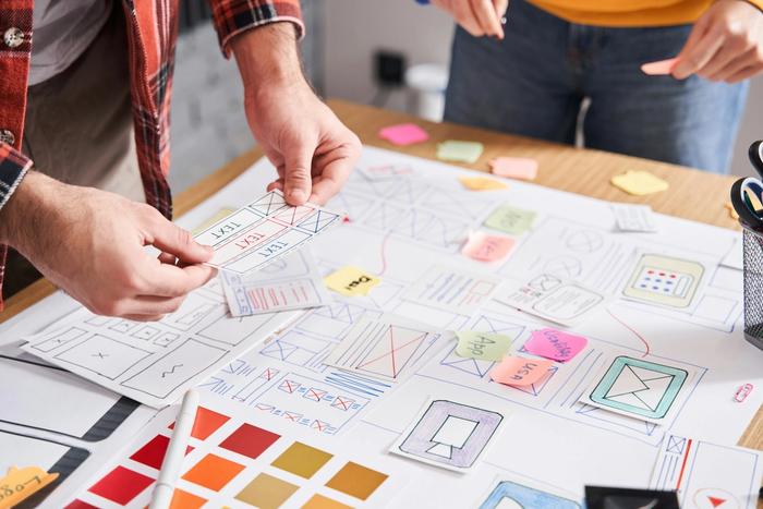 a man and a woman are sitting at a table working on a project .