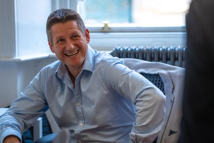 Image of CEO Steven Ledgerwood chatting in the office with long term employees