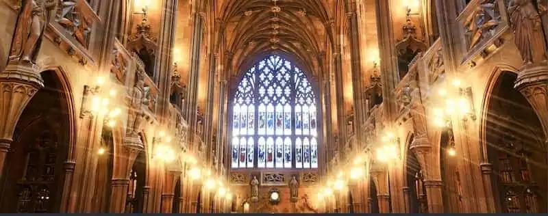 a large church with a stained glass window and lots of lights .