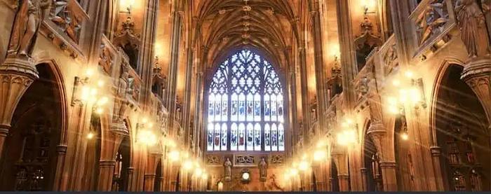 a large church with a stained glass window and lots of lights .