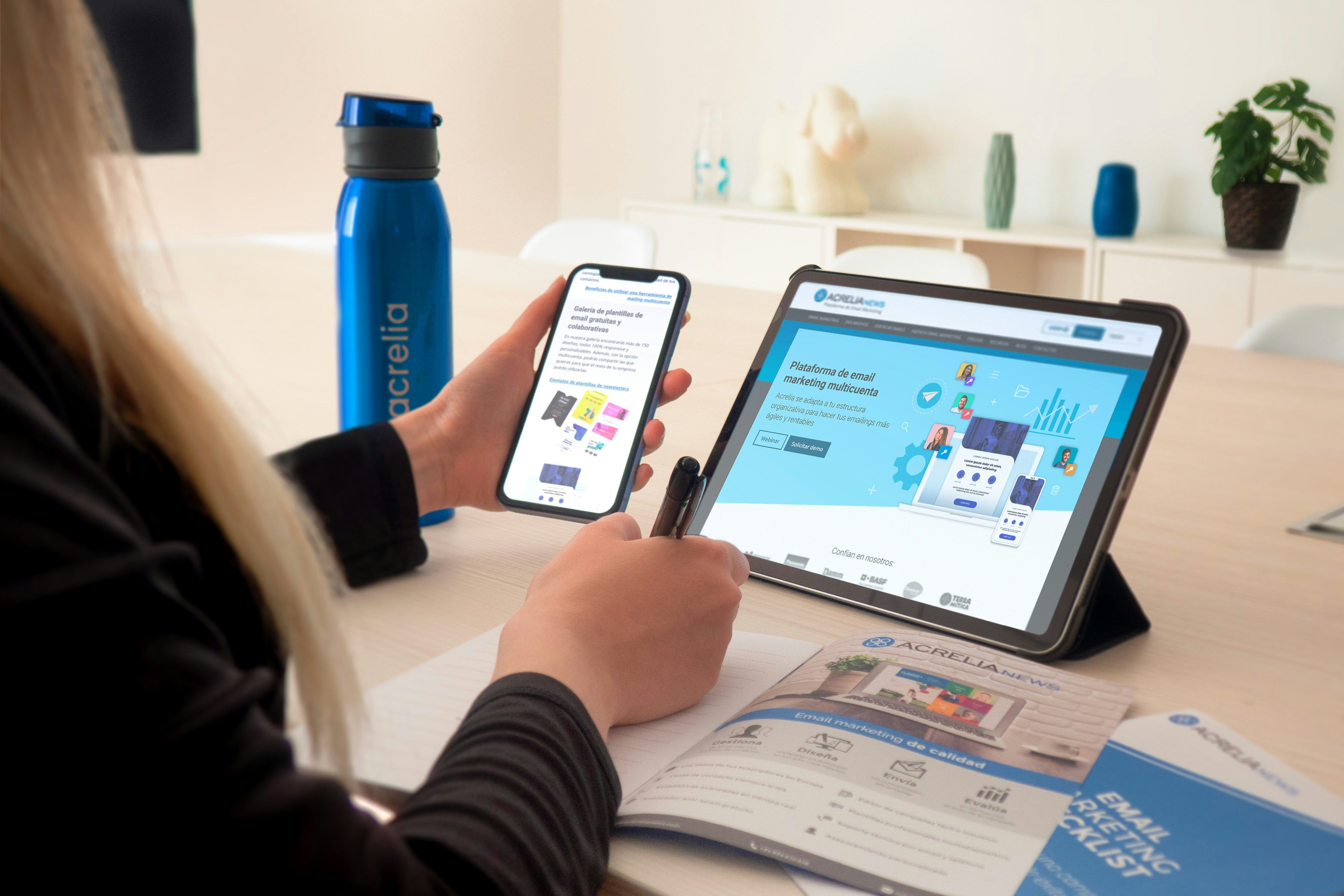 a woman is holding a cell phone and a tablet .
