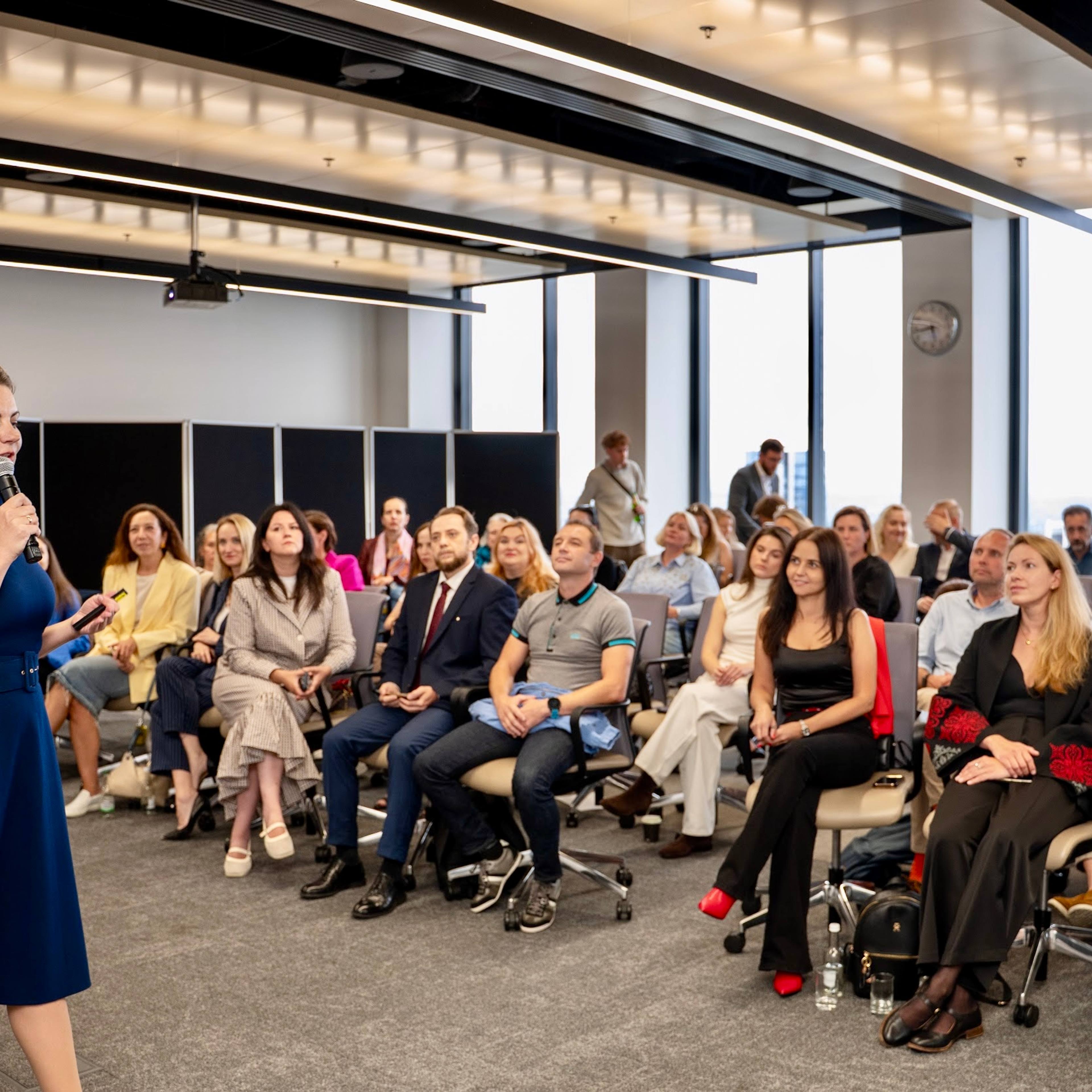 Nataliia Hrytsiuk speaks at The Next Generation of Entrepreneurs for Ukraine event at UCL School of Management, with Ukrainian and international participants seated in the audience.