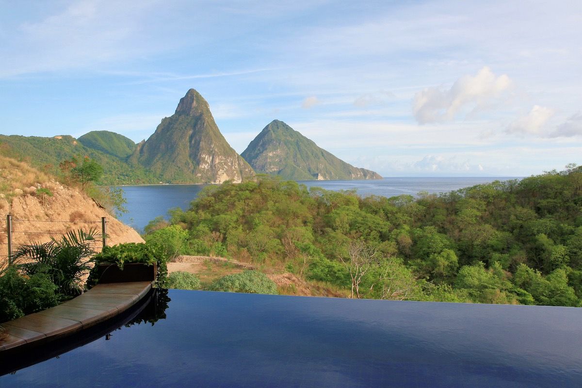 Infinity pool overlooking forested mountains and the sea